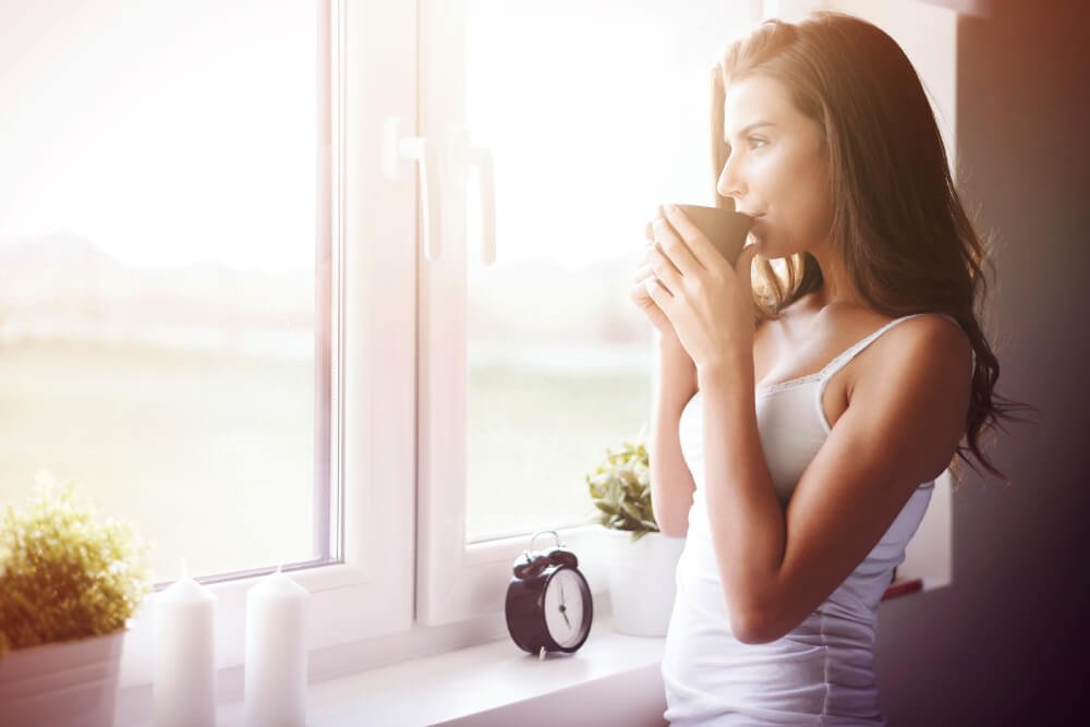 Person Looking Out Of A Window, Reflecting On Gratitude In The Quiet Morning Light.